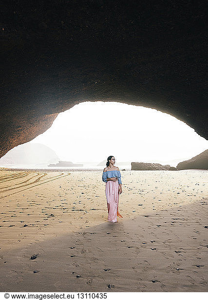 Frau steht am Strand am Berg