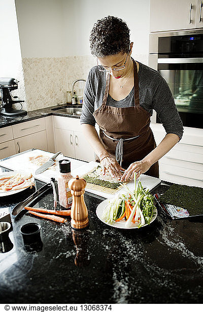 Frau streicht Fleisch auf Sushi-Matte