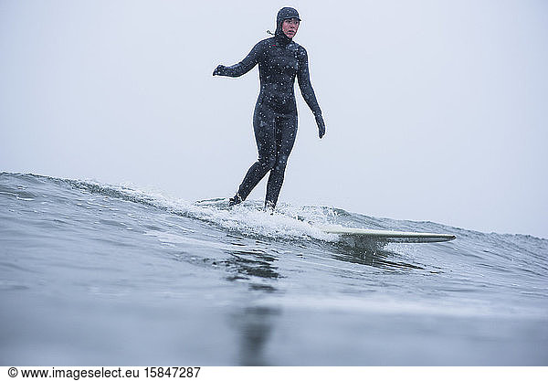 Frau surft im Winterschnee
