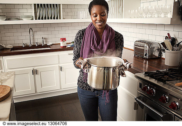 Frau trägt heiße Nahrungsmittel in Kochgeschirr