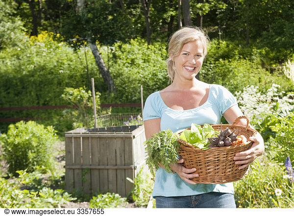 Frau trägt Korb mit Gemüse