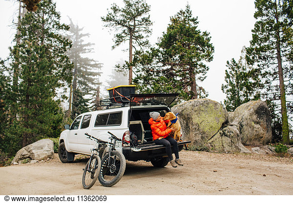 Frau und Hund sitzen auf der Heckklappe eines Jeepwagens  Sequoia-Nationalpark  Kalifornien  USA