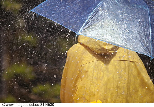 Frau unter Schirm im Regen