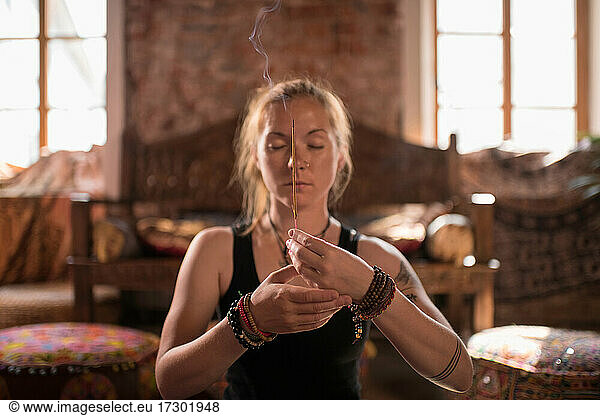 Frau verbrennt Weihrauch während der Meditation