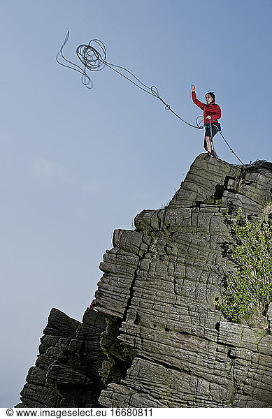 Frau wirft Seil an Windgather-Felsen im britischen Peak District