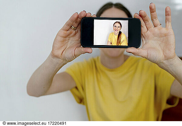 Frau zeigt Foto auf Smartphone