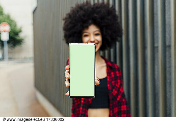 Frau zeigt Mobiltelefon mit leerem Bildschirm