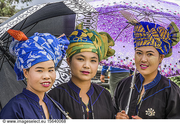 Frauen des Pa'O-Stammes  die eine bunte Kopfbedeckung tragen und mit Regenschirmen stehen; Yawngshwe  Shan-Staat  Myanmar