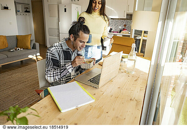 Freelancer eating snack and having coffee at home office