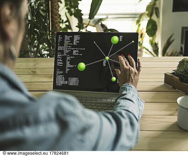 Freelancer pinching diagram on laptop screen at home