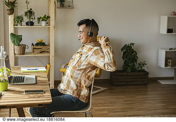 Freelancer stretching sitting on chair at home office