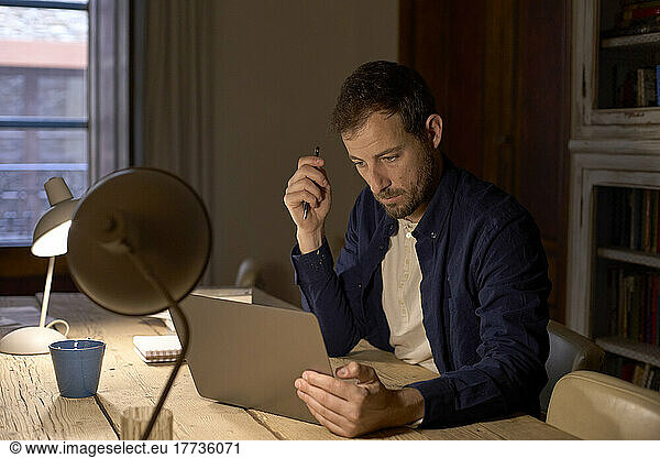 Freelancer using laptop on desk working at home