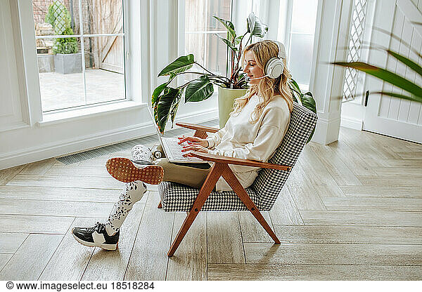 Freelancer with physical disabilities working on laptop at home