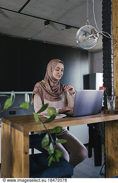 Freelancer working on laptop at home office