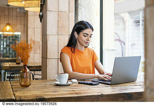 Freelancer working on laptop sitting in cafe