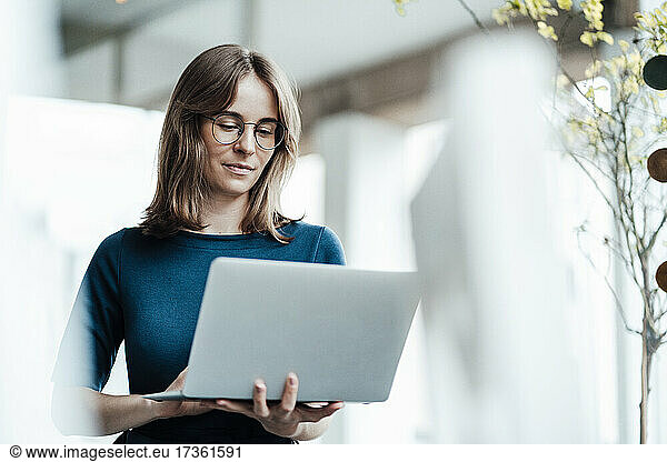 Freiberuflerin mit braunen Haaren benutzt Laptop in einem Café