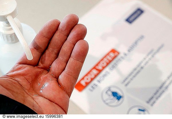 French election during coronavirus (COVID-19) crisis. Hands disinfection. Hands with disinfecting alcohol gel prevent virus epidemic.