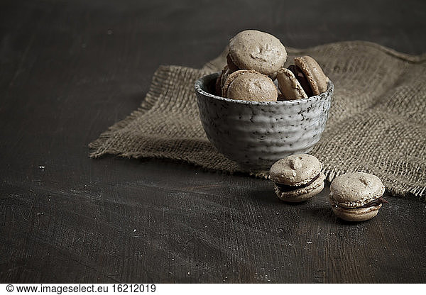 French Macarons filled with chocolate ganache in bowl