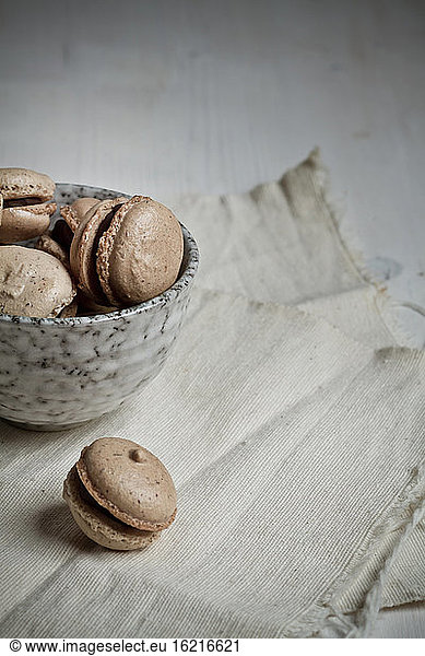 French Macarons filled with chocolate ganache in bowl