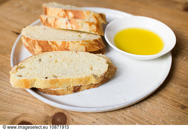 Fresh bread and olive oil on plate  close-up