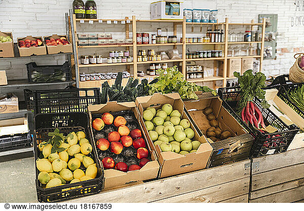 Fresh fruits and vegetables arranged in crates at greengrocer shop