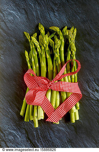 Fresh green asparagus bundle with red bow