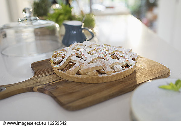 Fresh homemade baked lattice apple pie on cutting board