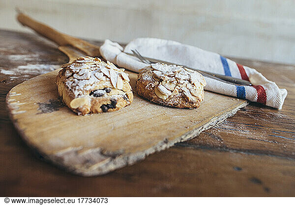 Fresh sweet rolls on wooden board in bakery