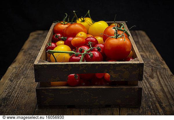 Fresh tomatoes in wooden crate