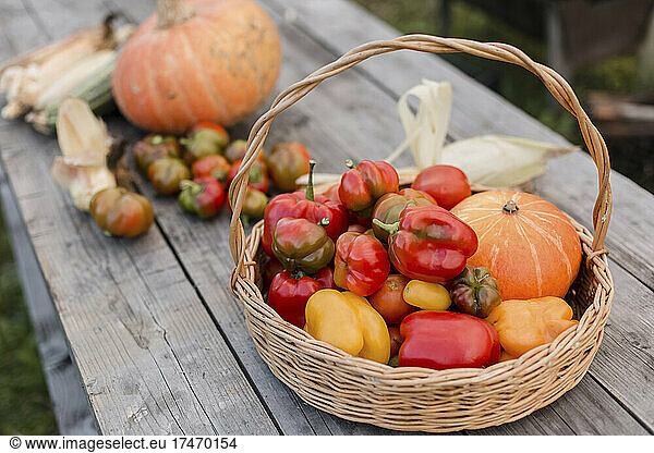 Fresh vegetables in basket on wooden table