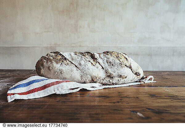 Freshly baked country bread on napkin in bakery