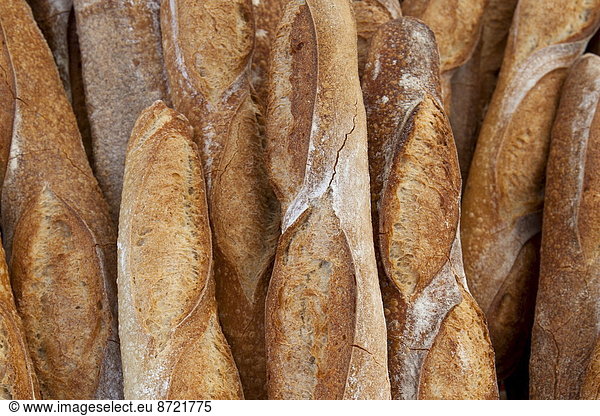 Freshly-baked French bread baguettes on sale at food market in Bordeaux region of France