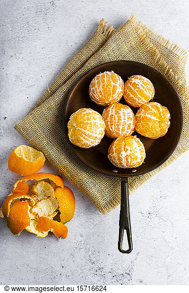 Freshly peeled mandarines on frying pan