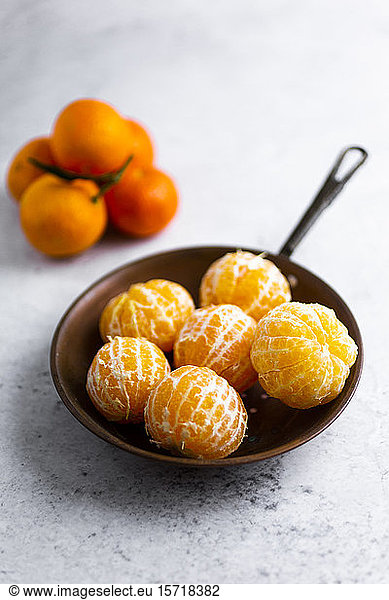 Freshly peeled mandarines on frying pan