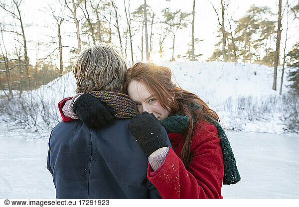Freund umarmt Freundin im Winter