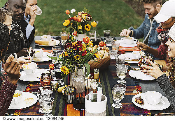 Freunde essen Essen  während sie im Hinterhof am Tisch sitzen