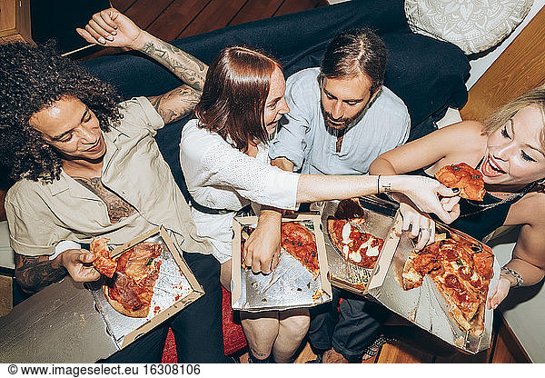 Freunde genießen Pizza beim geselligen Beisammensein zu Hause
