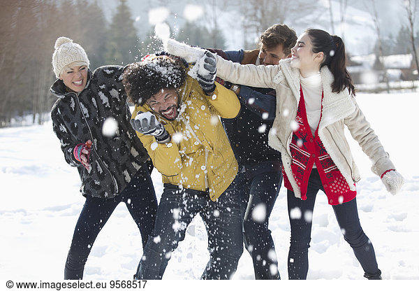 Freunde genießen Schneeballschlacht