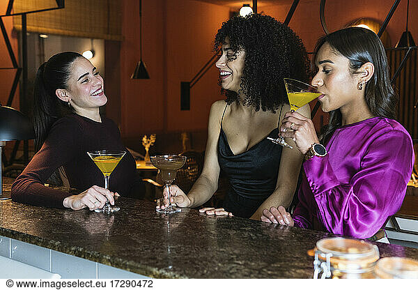 Freunde lächelnd bei einem Drink im Restaurant