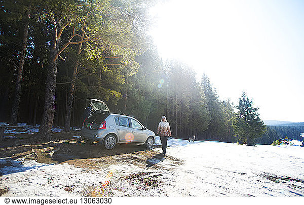 Freunde mit dem Auto im Wald an einem sonnigen Wintertag