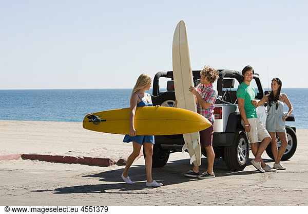 Freunde per Fahrzeug mit Surfbrettern