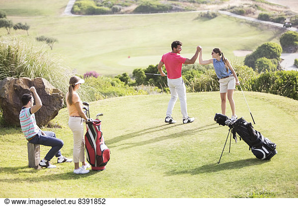 Freunde spielen Golf auf dem Platz