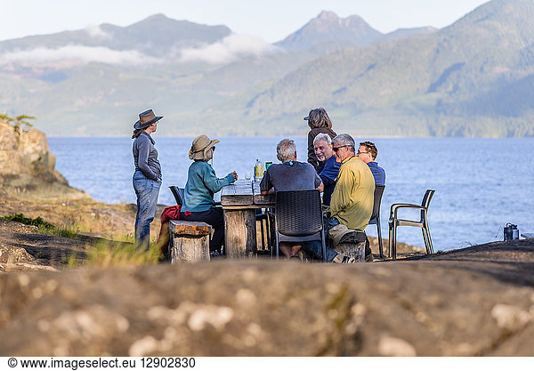 Freunde sprechen beim Abendessen am Seeufer  Johnstone Strait  Telegraph Cove  Kanada