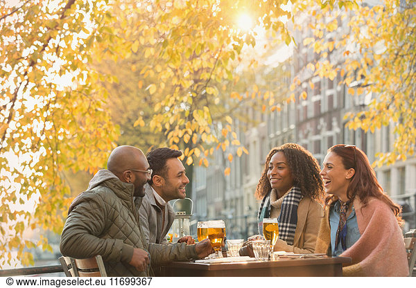 Freunde trinken Bier im Outdoor-Herbstcafé