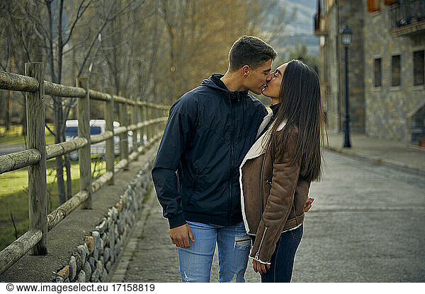Freundin und Freund küssen sich leidenschaftlich mit geschlossenen Augen in der Stadt