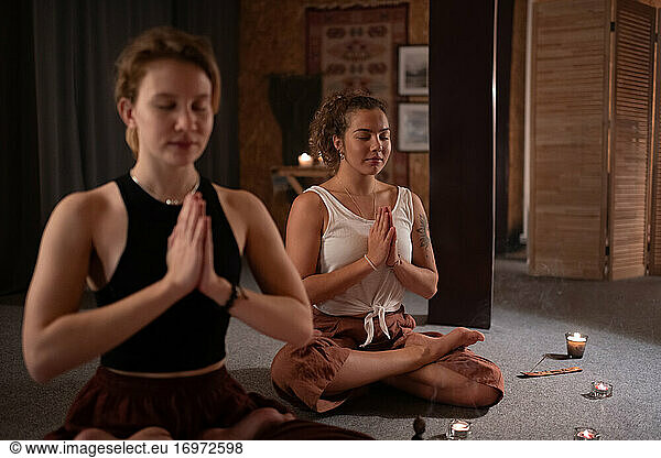 Freundinnen beim Meditieren am Abend