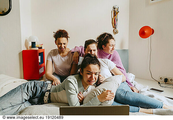 Freundinnen  die gemeinsam zu Hause einen Gruselfilm ansehen