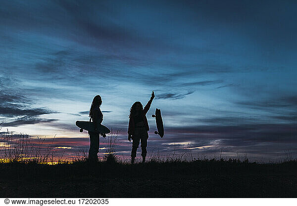 Freundinnen in Silhouette bei Sonnenuntergang