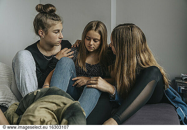 Freundinnen trösten traurige Teenagerin