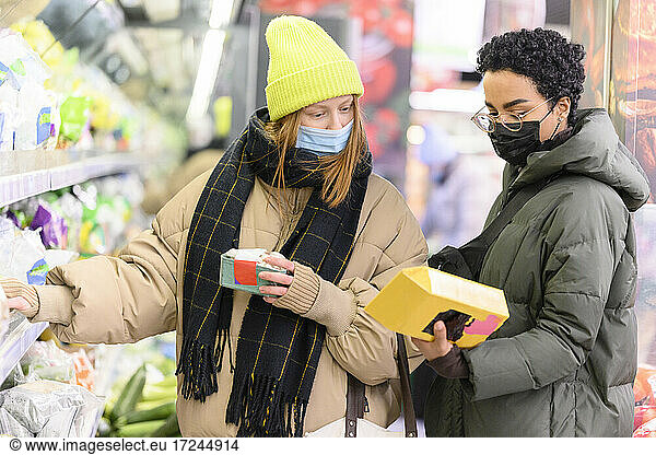Freundinnen tragen warme Kleidung im Supermarkt